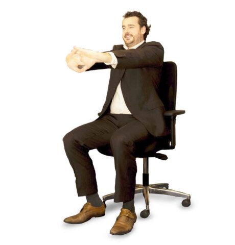 Een van de stoelyoga-houdingen die je gewoon op werk kan doen
